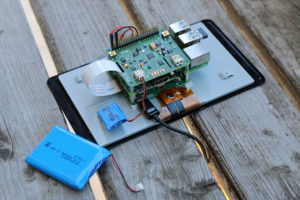 Abbildung 1: Die S.USV&nbsp;pi advanced mit dem 300-mAh-Akku auf einem RasPi mit dem offiziellen Display der Raspberry&nbsp;Pi Foundation. Im Vergleich dazu der große Akku mit 3000&nbsp;mAh Kapazität.