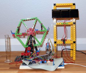 Abbildung 1: Der Testaufbau im &Uuml;berblick: Die drei Solarpaneele rechts laden die Brennstoffzelle (Mitte), die dann das Riesenrad links antreibt.