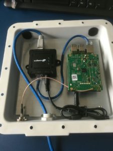 Abbildung 2: Das Innere eines LoRaWAN-Gateways nach Anleitung von TTN-ZH. Man sieht die Durchführungen für die Antenne und das Ethernet-Kabel, den Power-over-Ethernet-Splitter und insbesondere den Raspberry Pi 2 mit LoRaWAN-HAT (IC880-SPI-Variante).