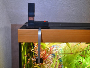 Abbildung 1: Der selbst konstruierte Futterautomat auf Basis eines Raspberry Pi mit Kamera an der Seitenscheibe des Aquariums.